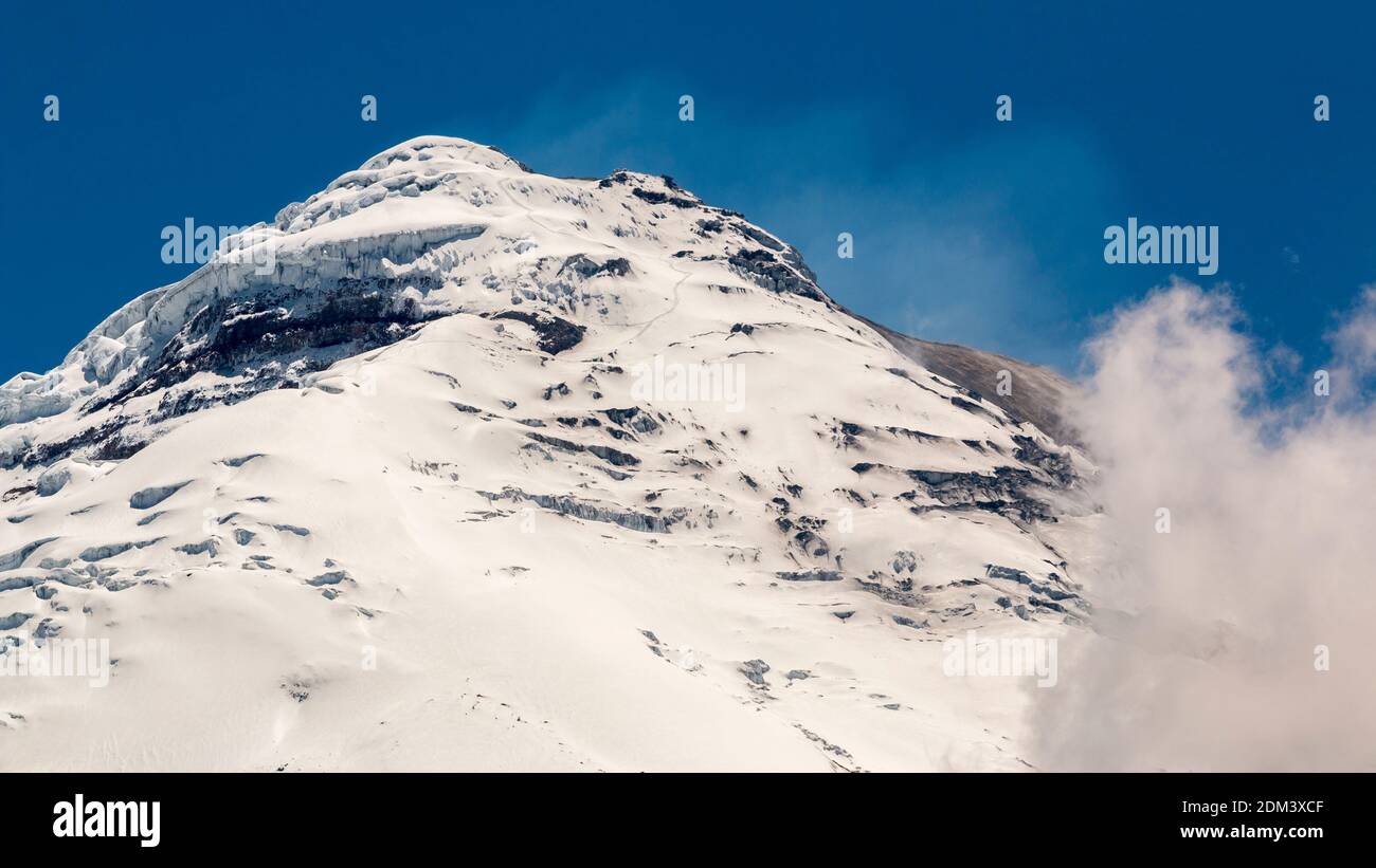 The snowcapped Cotopaxi Volcano in Ecuador with vapour erupting from the crater on the summit. One of the world's highest active volcanoes at 5,897m. Stock Photo