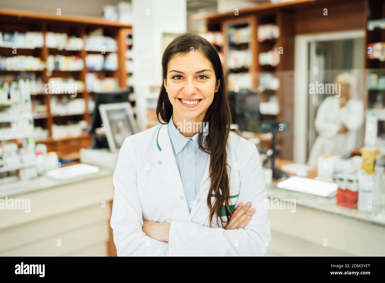 Smiling friendly pharmacist at the counter working in a pharmacy store. Pharmaceutical professional therapy recommendation. Giving advice about medica Stock Photo