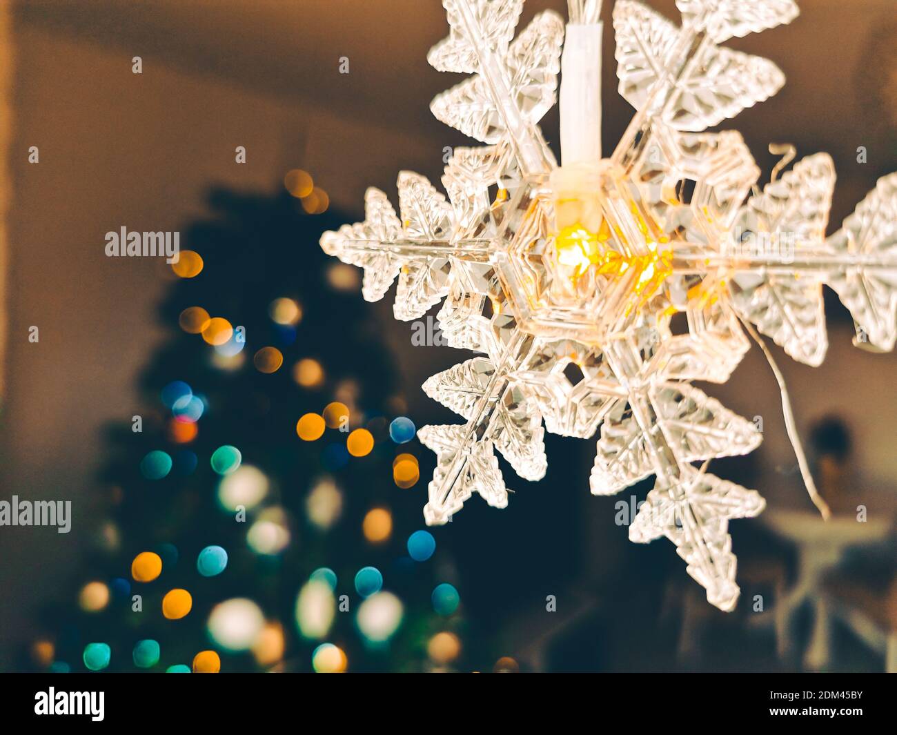 Cosy atmosphere for Christmas with Christmas lights in foreground and bokeh effect on Christmas Tree Stock Photo