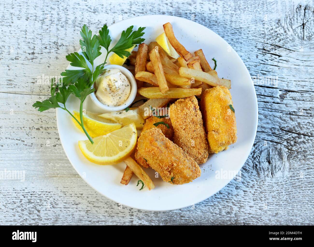 Crispy fish and chips, served with mayonnaise and lemon on wooden table  Stock Photo - Alamy