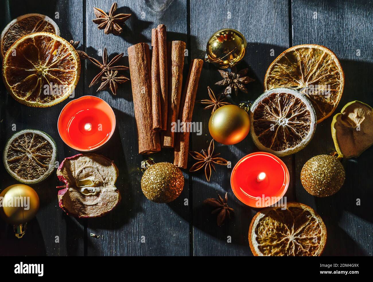 Christmas still life with cinnamon sticks, orange slices and candles Stock Photo