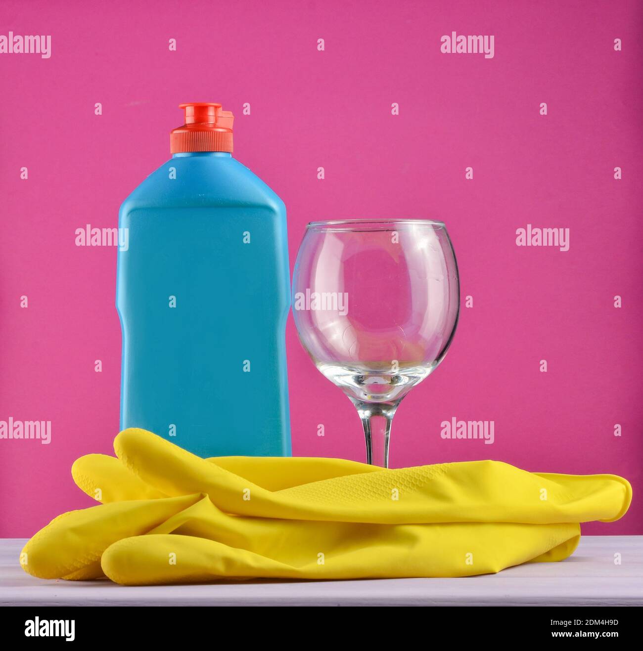 https://c8.alamy.com/comp/2DM4H9D/accessories-for-dishwashing-and-house-cleaning-dishwashing-bottle-of-detergentglass-and-yellow-rubber-gloves-on-pink-background-2DM4H9D.jpg