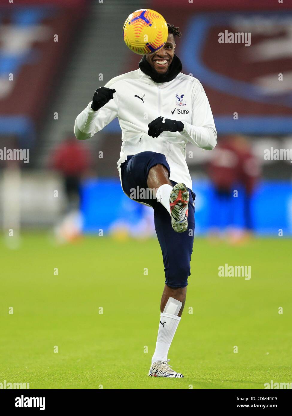 Crystal Palace's Wilfried Zaha warms up during the Premier League match at the London Stadium. Stock Photo