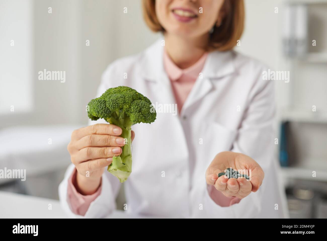 Dietitian or nutritionist recommends eating raw vegetables and taking food supplements Stock Photo