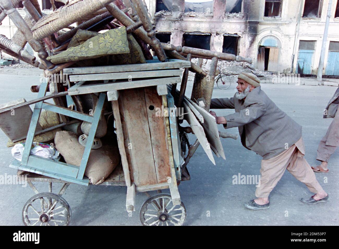 An Afghan shopkeeper pushes a cart with his belongings after his store was hit by rockets fired by forces loyal to warlord Gulbuddin Hekmatyar April 27, 1992 in Kabul, Afghanistan. Following the collapse of the Democratic Republic of Afghanistan rival faction of mujahideen began a battle for the city. Credit: Planetpix/Alamy Live News Stock Photo