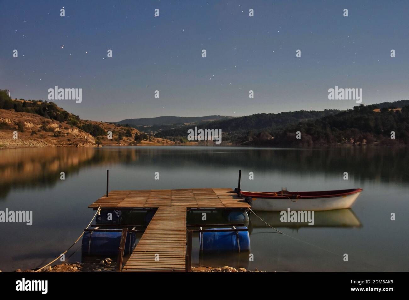 Boat Moored On Lake Against Sky At Night Stock Photo