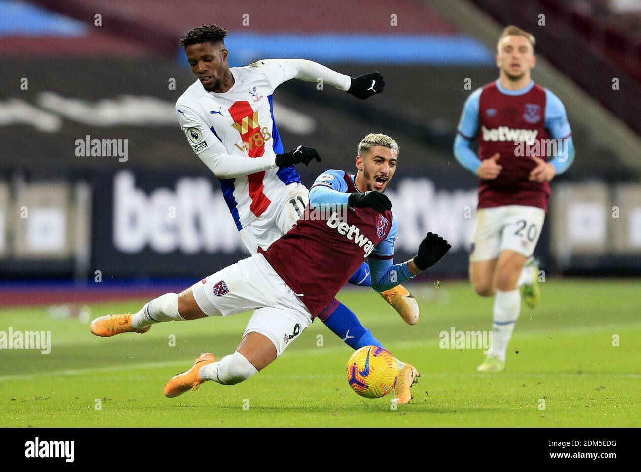 West Ham United's Said Benrahma and Crystal Palace's Wilfried Zaha battle for the ball during the Premier League match at the London Stadium. Stock Photo