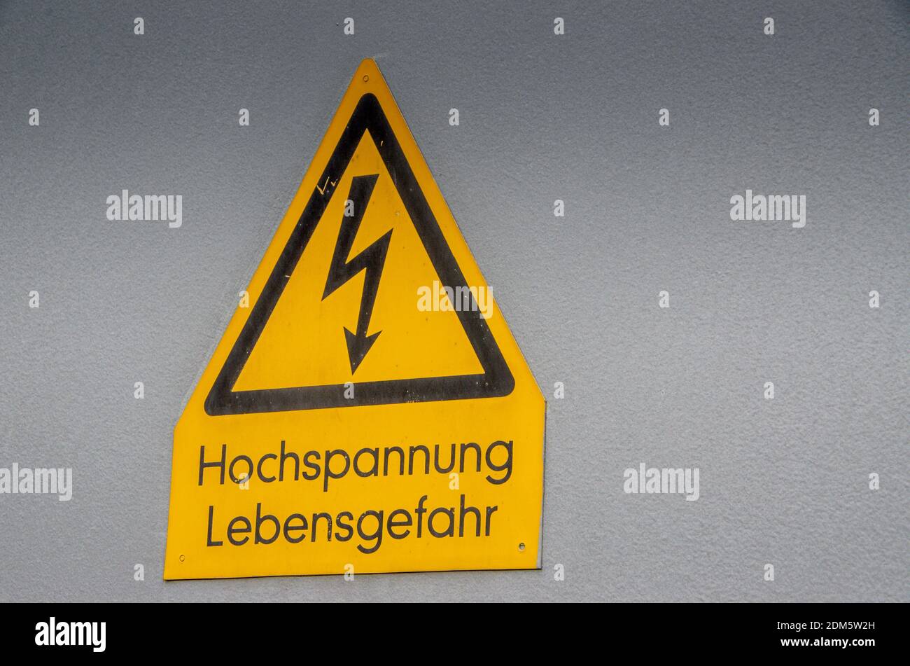 Signboard High voltage danger to life isolated on white surface. Stock Photo