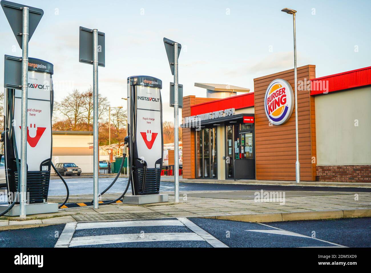 Electric vehicle (EV) rapid charging point outside a Burger King drive thru restaurant, UK. Stock Photo