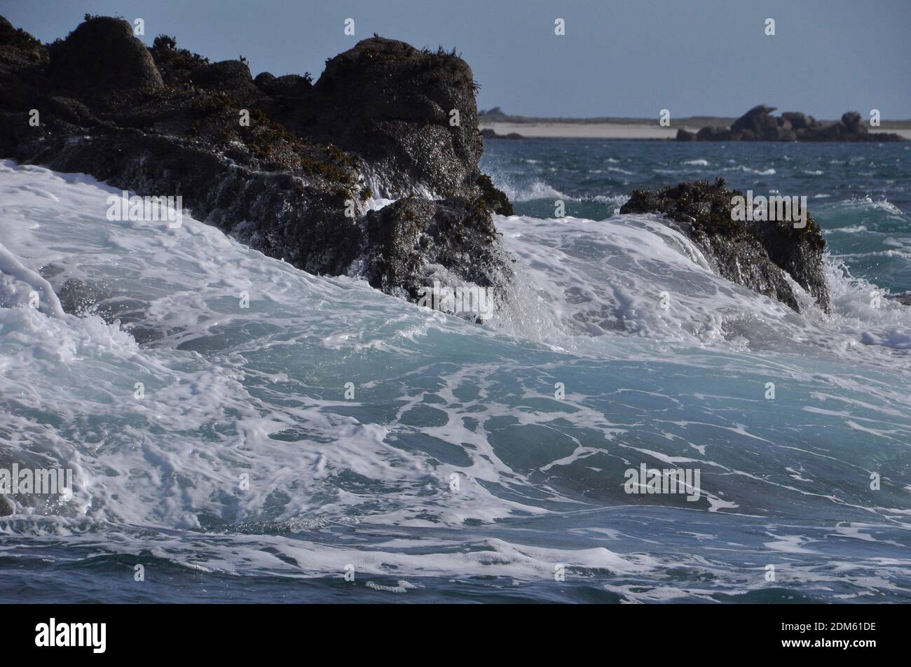 The sea surging over the seaweed covered granite Norrard rocks, part of