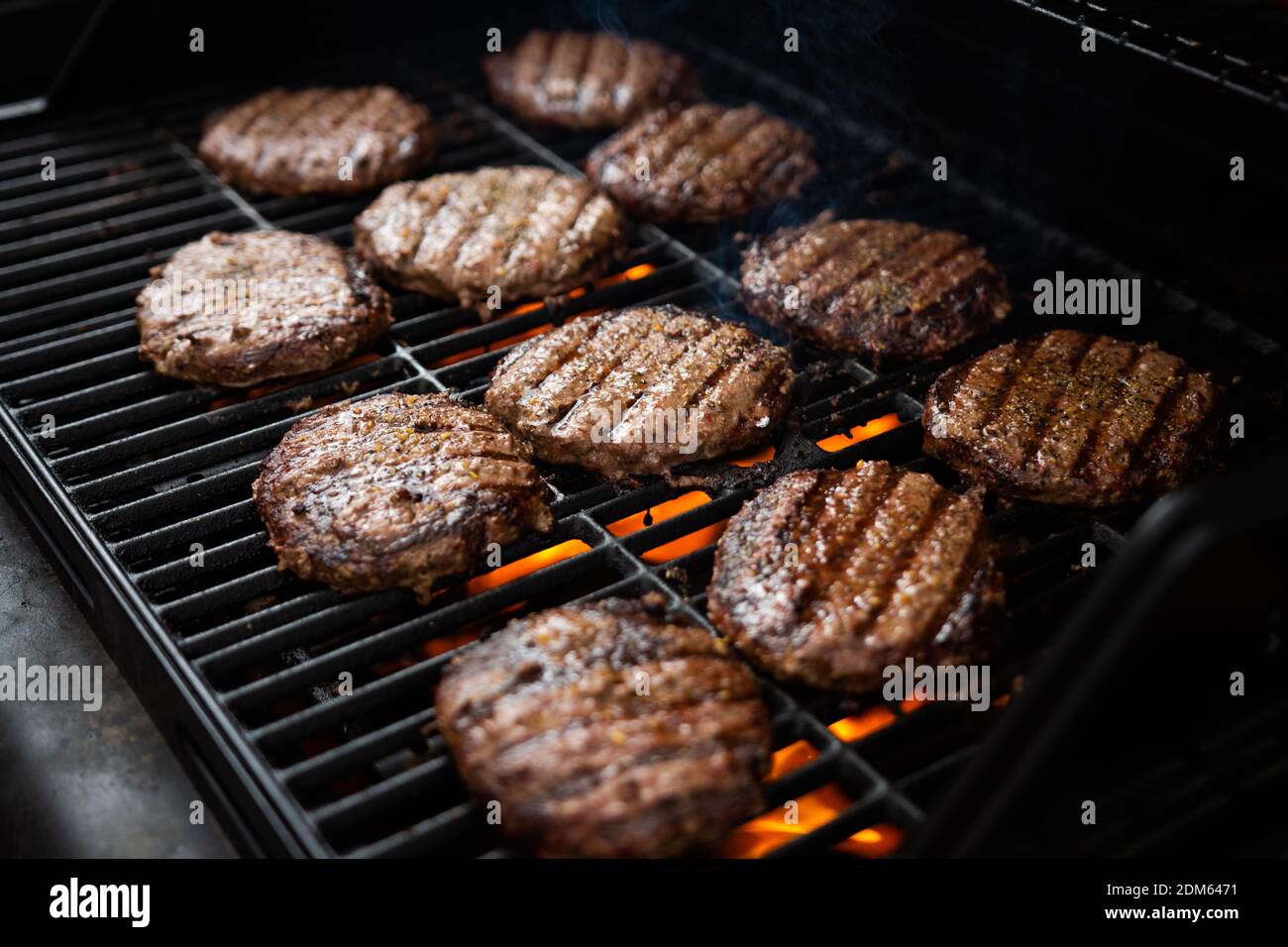 Hamburgers and hot dogs cook on flame charred backyard grill Stock ...