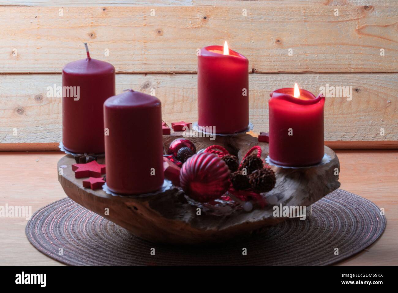 Red burning candles on an Advent arrangement. It is the third Advent. Christmas is coming soon. Stock Photo