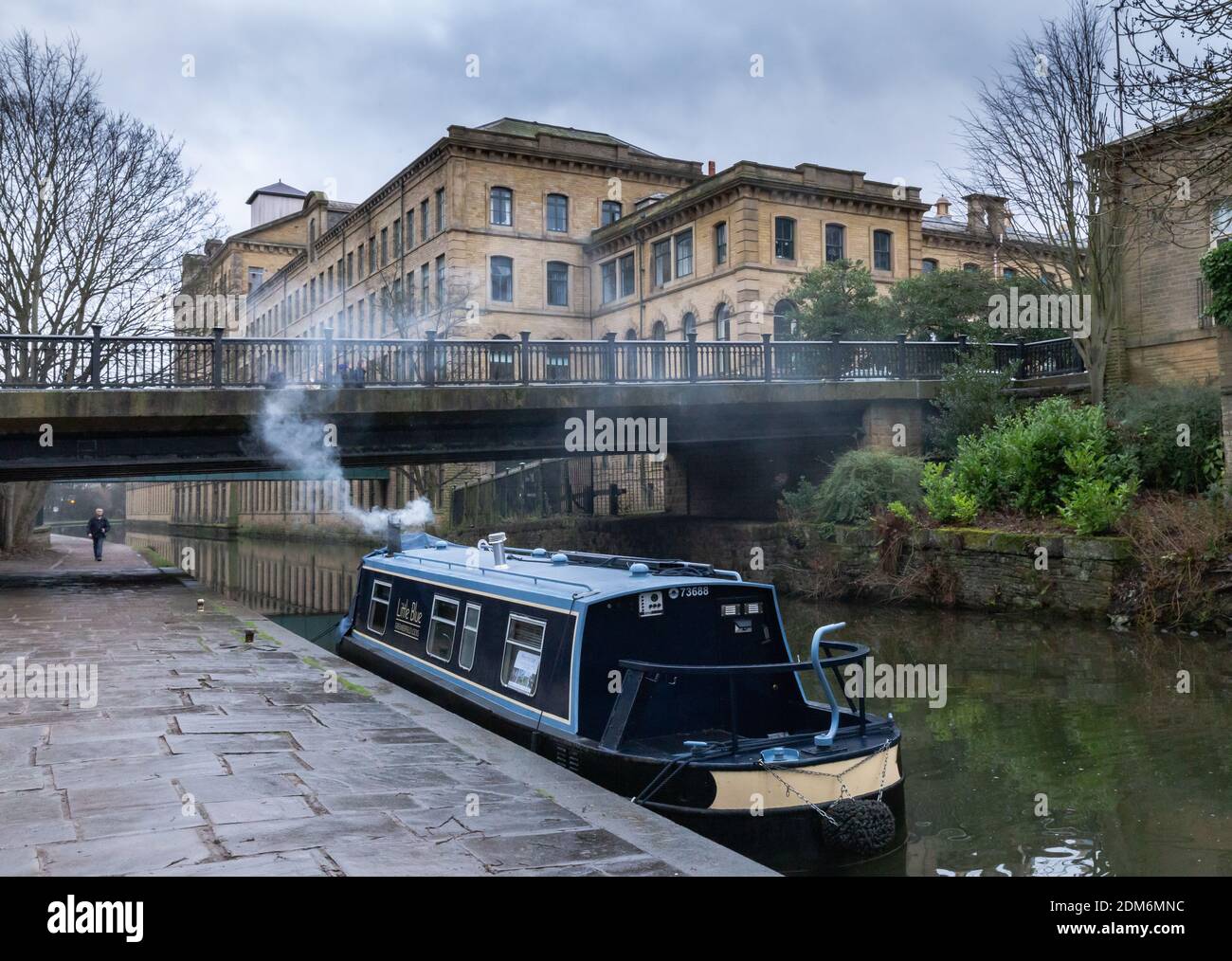 A narrow boat on the Leeds Liverpool Canal at Saltaire, Yorkshire. Salts Mill is in the background. Stock Photo