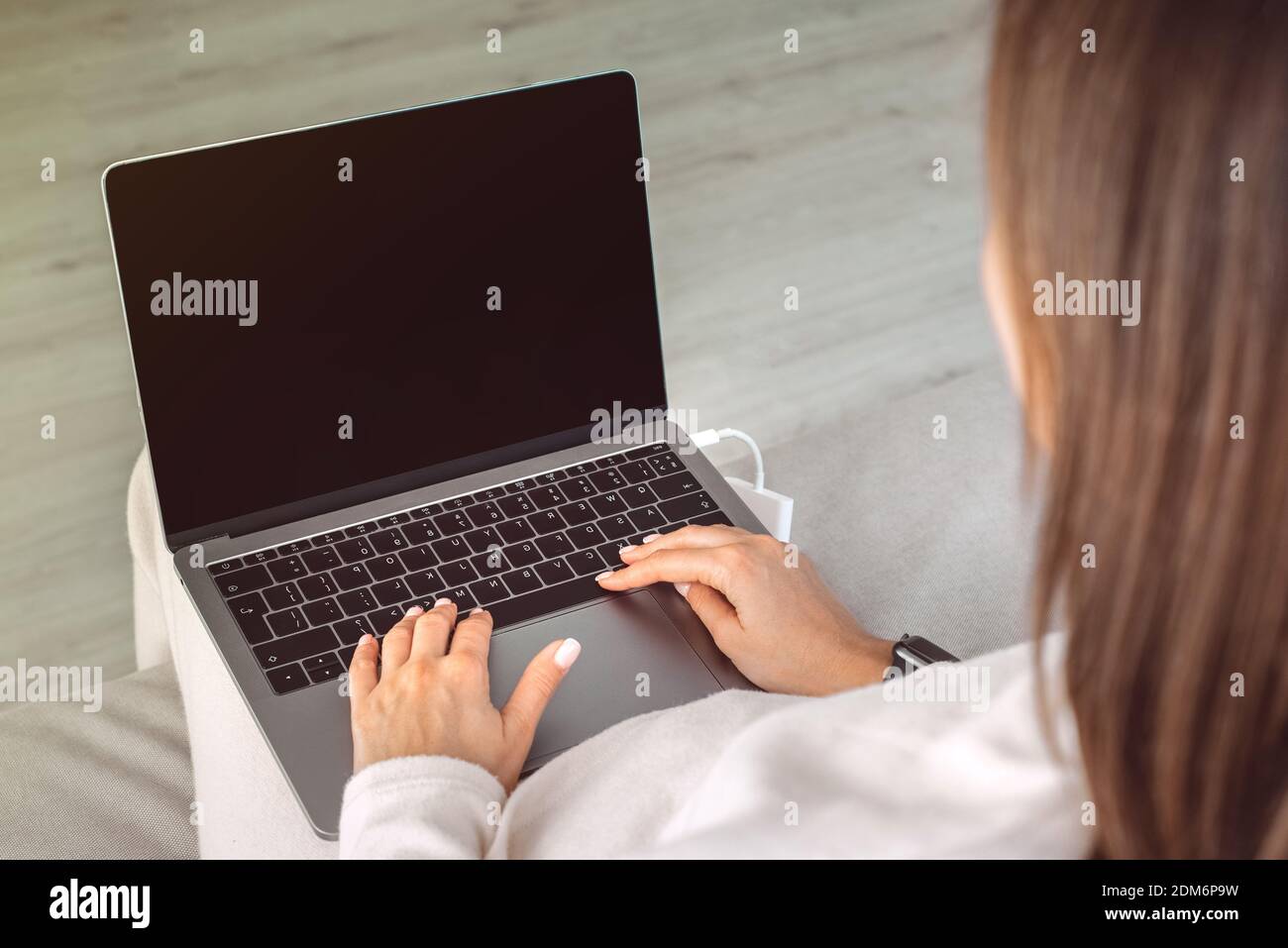 Close up of woman working at home on a laptop with black screen.Online education Stock Photo