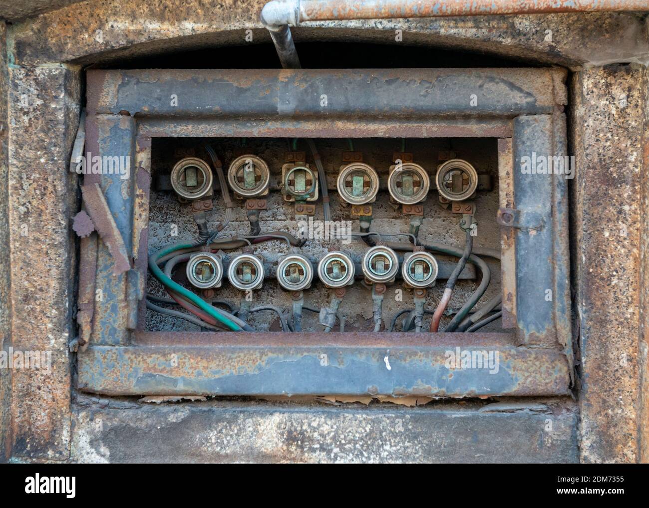 Disused old-fashioned electrical distribution board and old fuses in neglected abandoned building Stock Photo