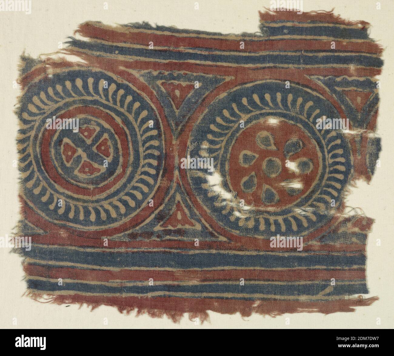 Fragment, Medium: cotton Technique: resist-printed on plain weave, Unbleached plain weave cloth. Design in blue and red. Two circles, approximately 21 cm in diameter: one in blue with white detail, red center with blue heart-shaped detail; the other, similar framing smaller circle with crossed bars in center. Above and below, borders of blue stripes. Printing crude., India, 12th–13th century, printed, dyed & painted textiles, Fragment Stock Photo