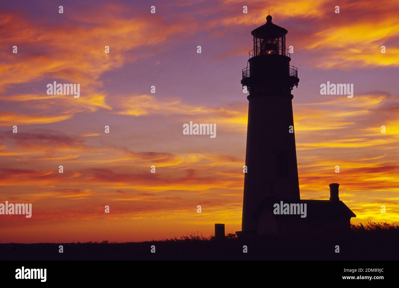 Sunset silhouettes the Yaquina Head Lighthouse, managed by the U.S ...