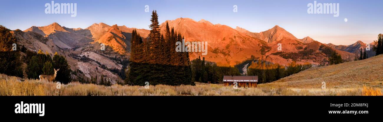 Sun set as moon rises above Idaho's Pioneer Mountains and the historic Pioneer Cabin built by Union Pacific Railroad for ski tourers in 1937. Stock Photo