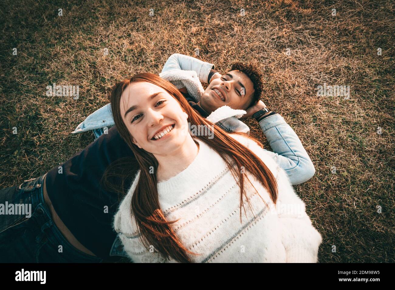 Aerial Shot Of A Happy Couple Lying On The Grass Stock Photo - Alamy