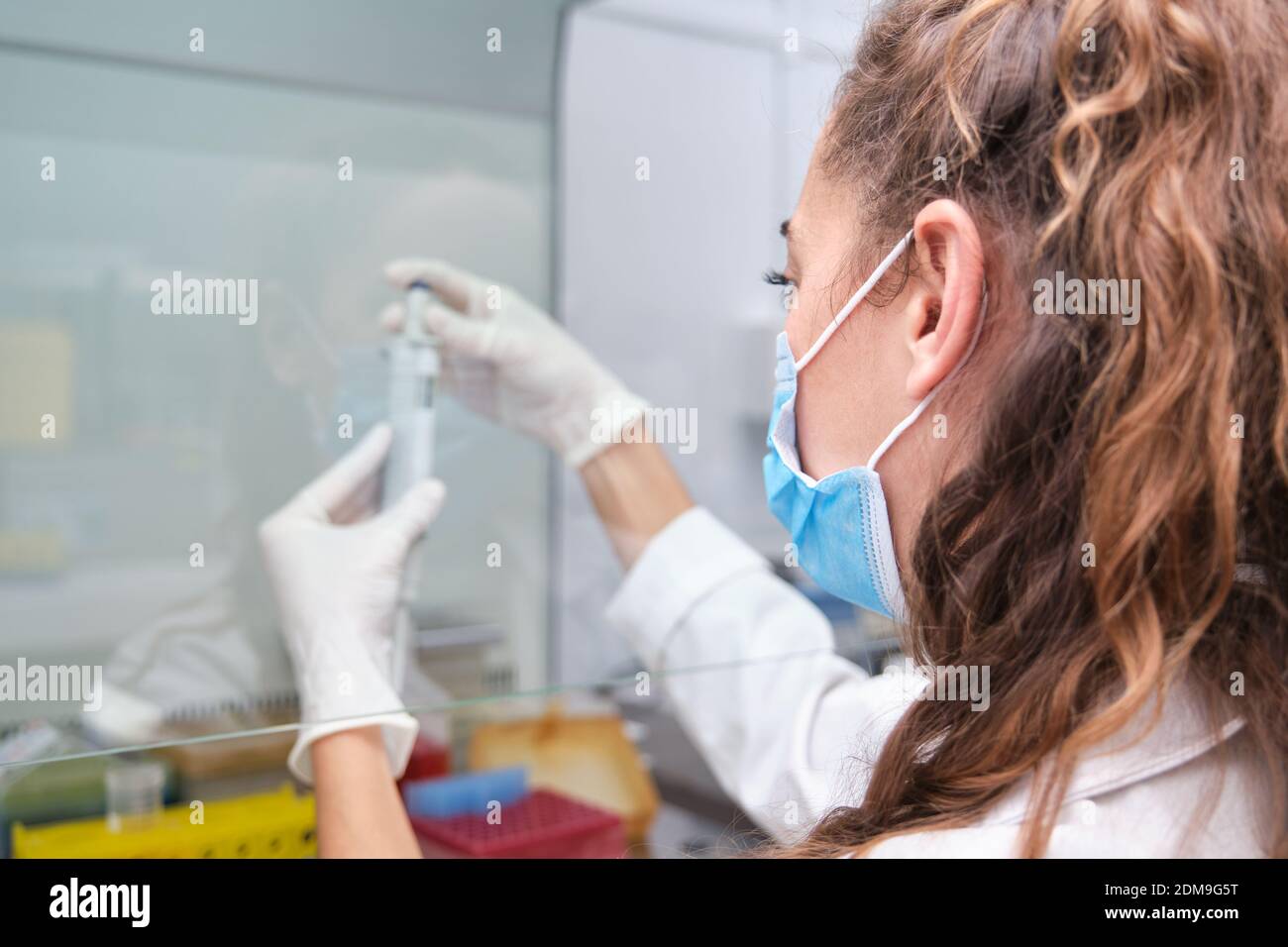 Young female scientist wearing face mask during an experiment in a