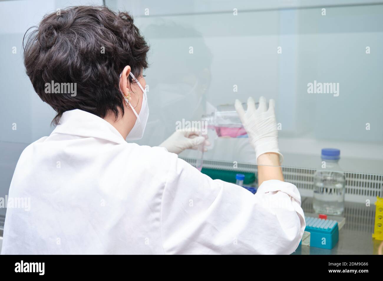 Young female scientist wearing face mask during an experiment in a