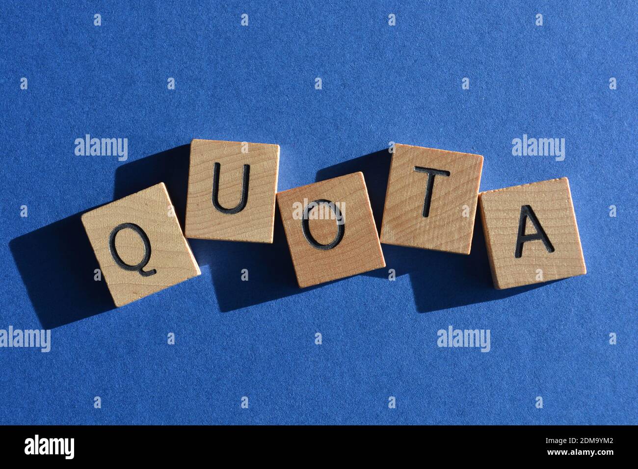 Quota, word win wooden alphabet letters isolated on blue  background Stock Photo