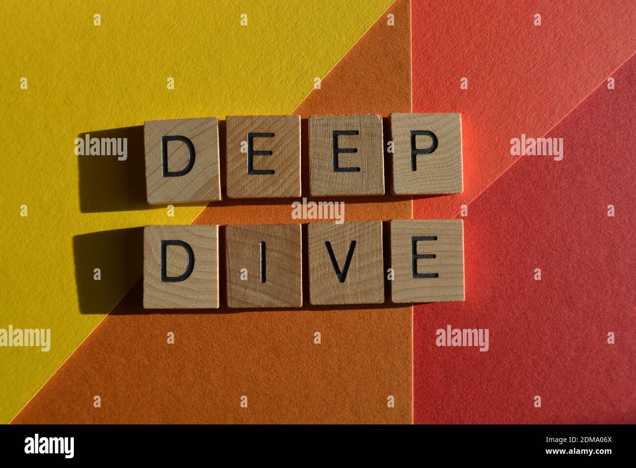 Deep Dive, words in wooden alphabet letters isolated on colourful background Stock Photo