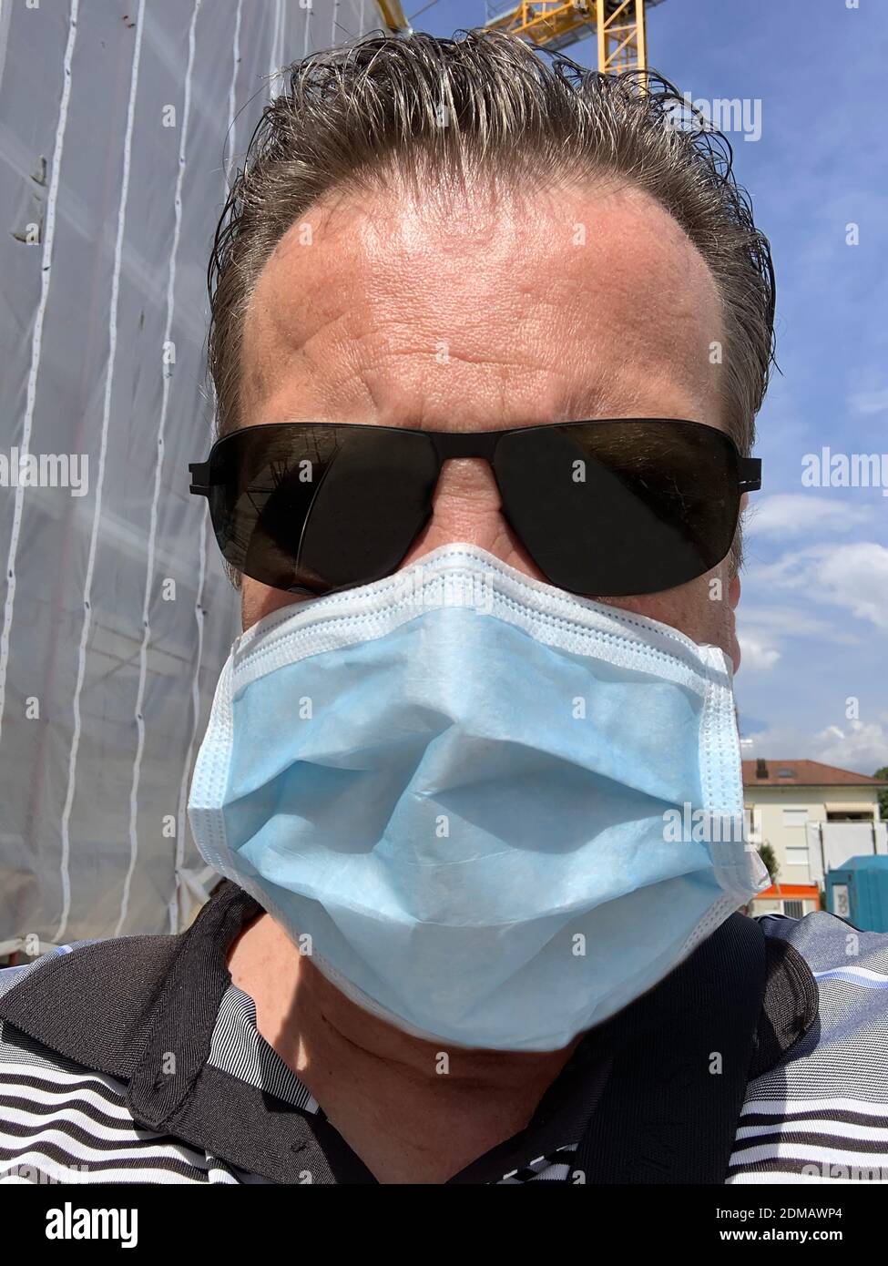 Headshot on a Man With Face Mask and Sunglasses on a Construction Site in  Switzerland Stock Photo - Alamy