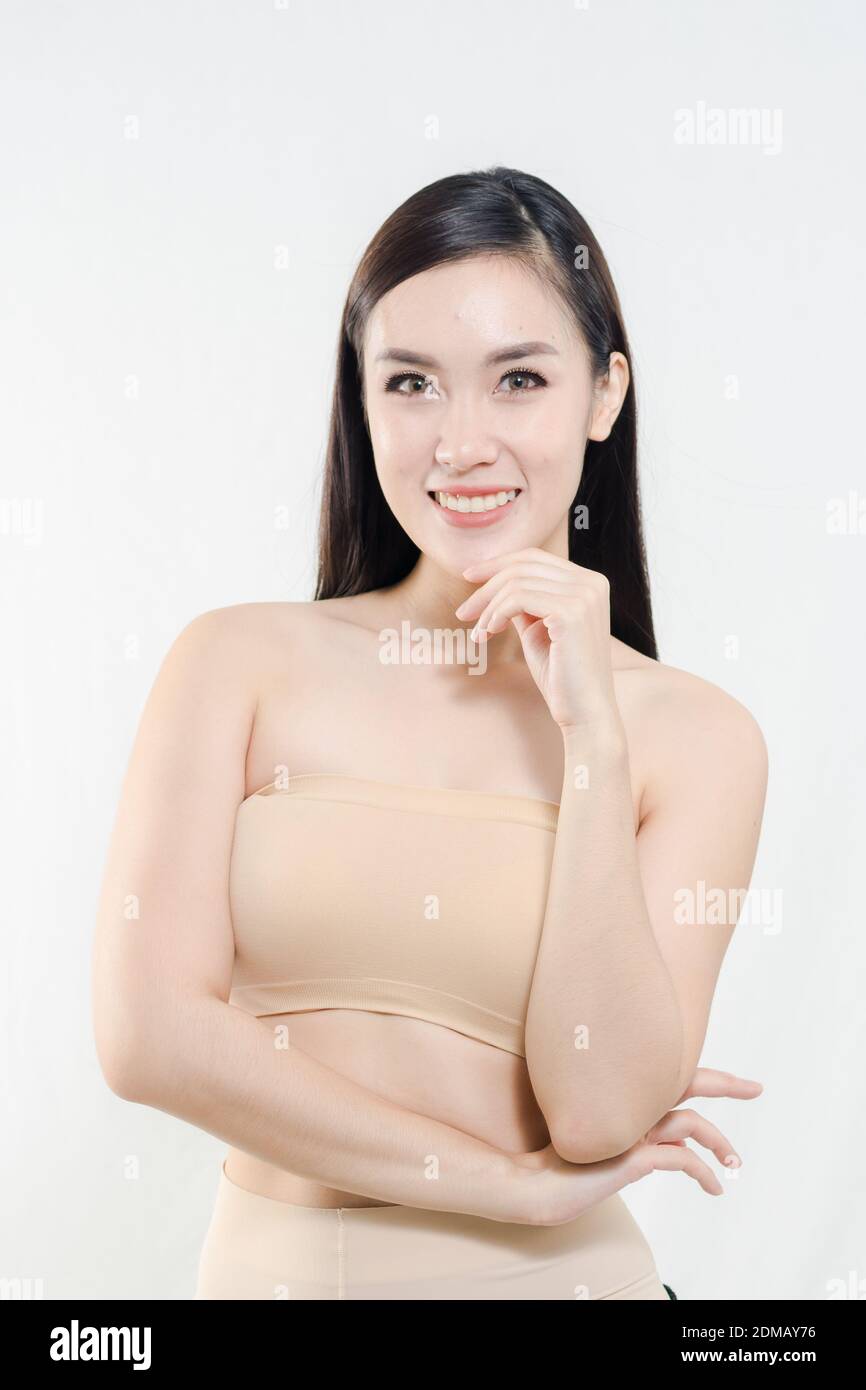 Portrait Of Smiling Young Woman With Hand On Chin Against White Background Stock Photo