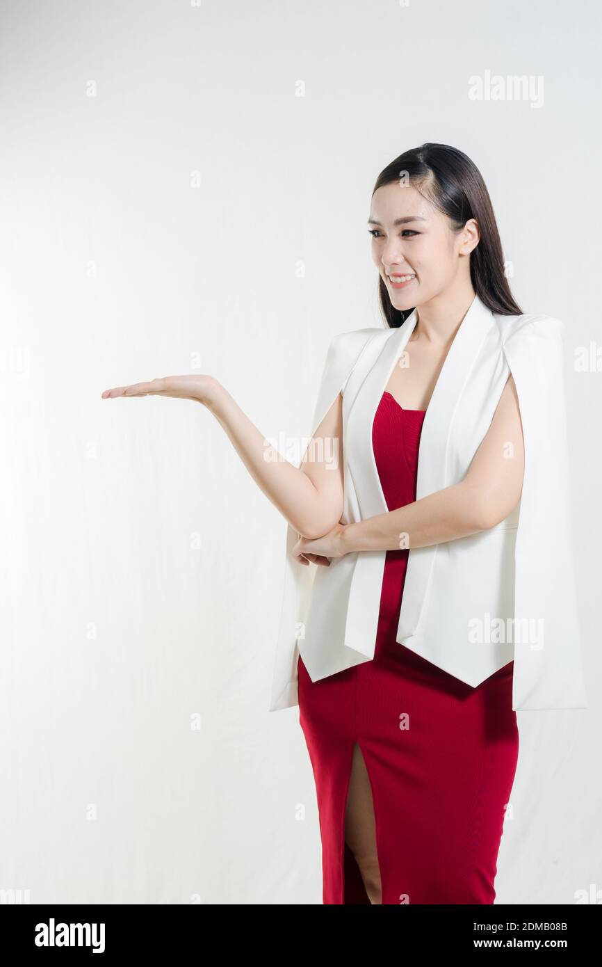 Smiling Young Businesswoman Gesturing While Standing Against White Background Stock Photo
