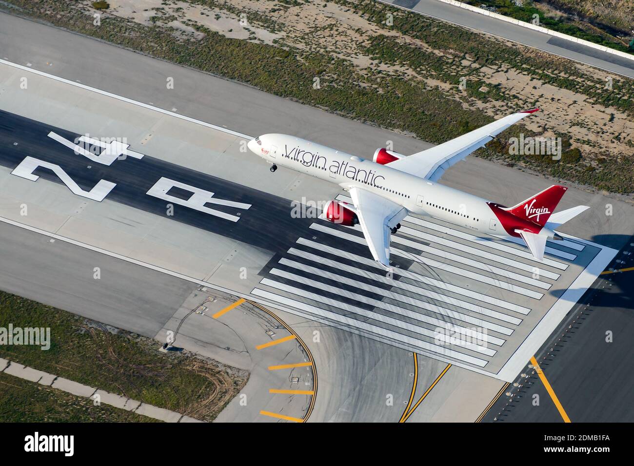 Virgin Atlantic aircraft Boeing 787 Dreamliner passing over airport runway threshold. Airplane B787 (787-9) landing aerial view. Stock Photo