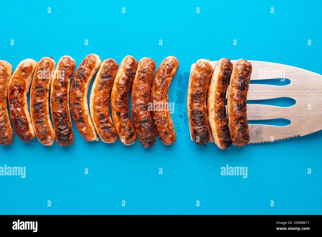 Above view with grilled bavarian bratwurst on blue background