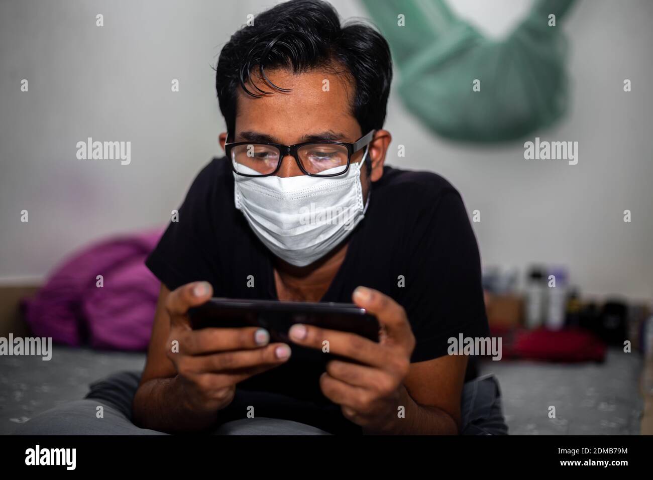 Portrait of a young man playing Mobile video games at Night deu to coronavirus epidemic. Stock Photo