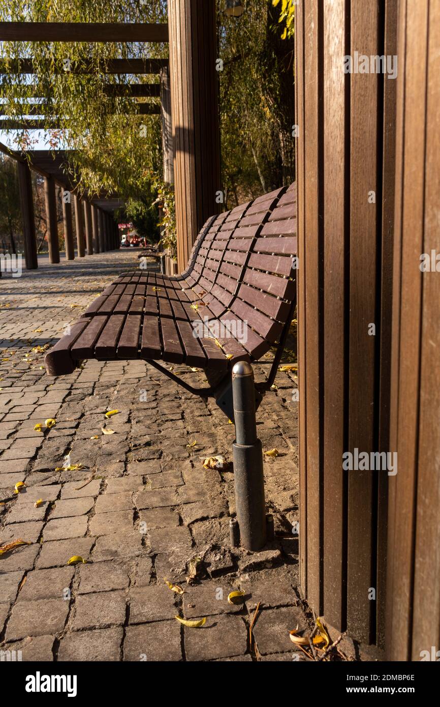A vertical shot of modern empty benches in the park Stock Photo - Alamy