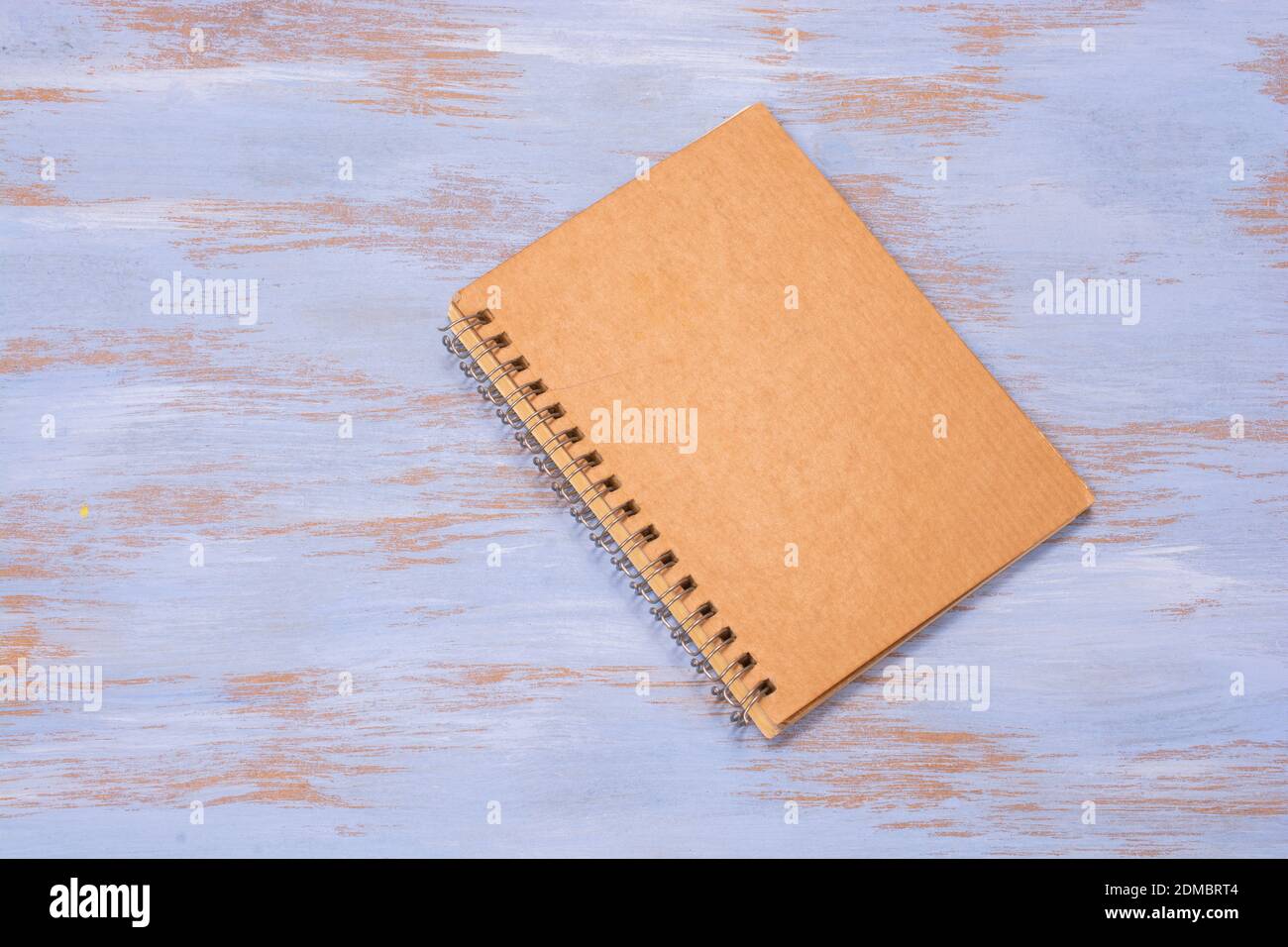 A cardboard notebook cover on a blue wooden surface Stock Photo