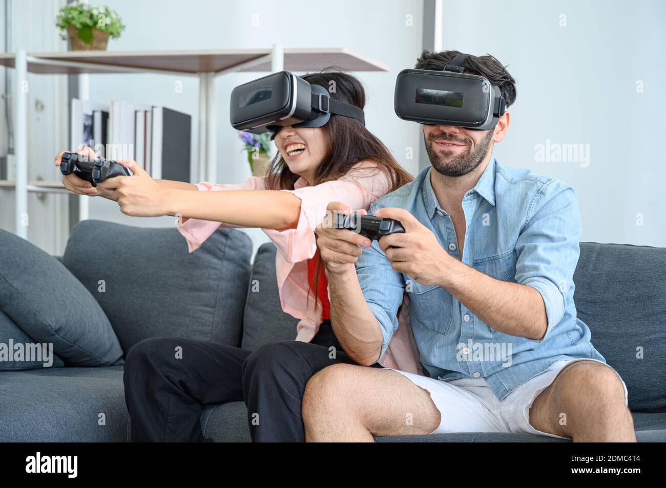 Couple lovers enjoy  playing VR game together at home. Family relationship concept. Stock Photo