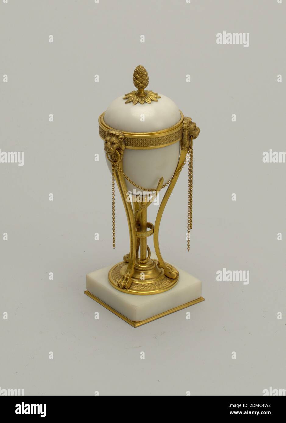 Cassolette (perfume burner or essence vessel), Marble, gilt bronze, Part a, square marble plinth supporting gilt bronze tripod with lions feet and heads; snake twisted around center stem; marble bowl mounted in wide band; double chains hanging from ring held by lions' heads. Part b, dome-shaped marble lid with gilt bronze pine cone finial; interior fitted with gilt bronze nozzle for candle (can be inverted to act as candle holder)., France, ca. 1785–90, metalwork, Decorative Arts, Cassolette (perfume burner or essence vessel Stock Photo