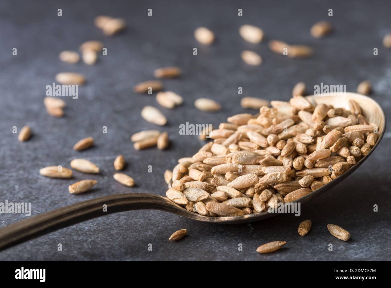 Close-up Of Groats In Spoon On Table Stock Photo