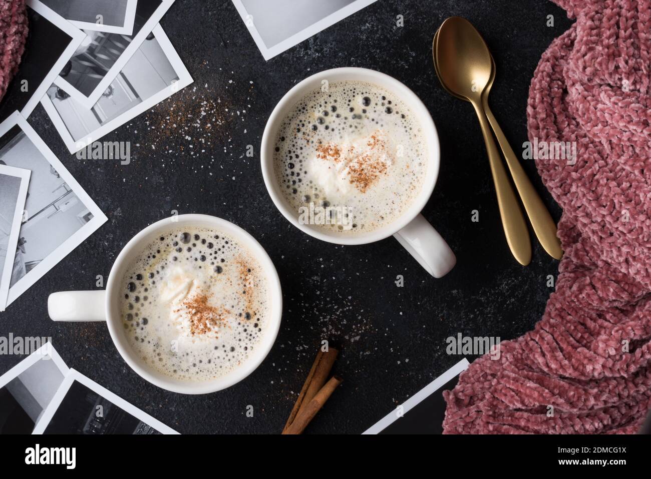 Directly Above Shot Of Coffee In Cups By Photographs On Table Stock Photo