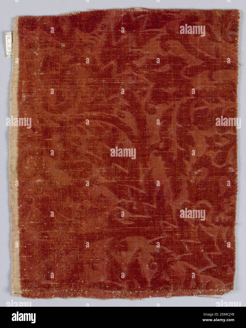 Fragment, Medium: wool mohair Technique: supplementary warp pile (velvet), embossed, Fragment of embossed wool velvet with a pattern of scrolling stems and leaves, in deep red., Flanders, 16th century, woven textiles, Fragment Stock Photo