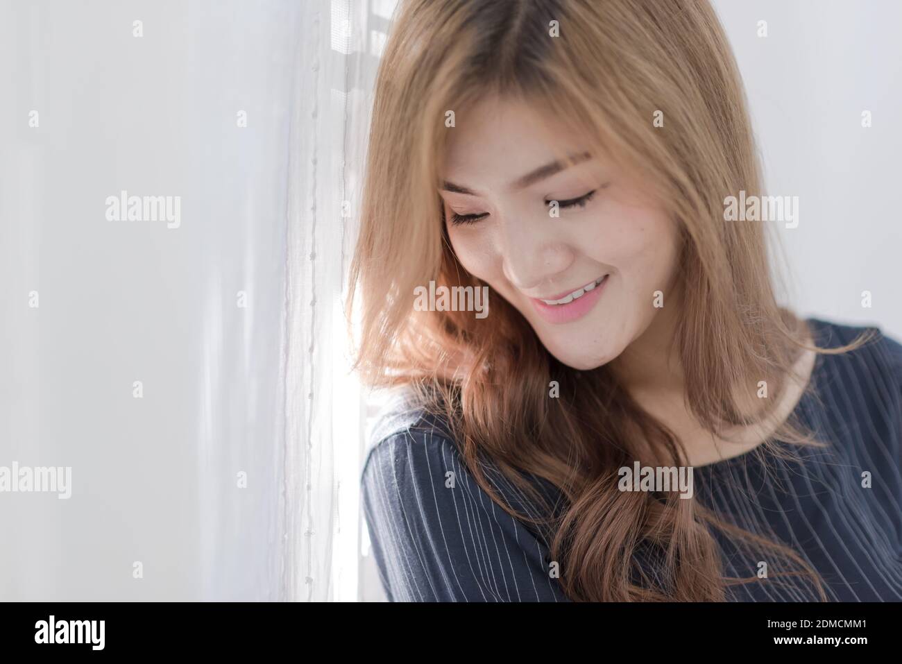 Close-up Of Beautiful Young Woman Looking Away At Home Stock Photo