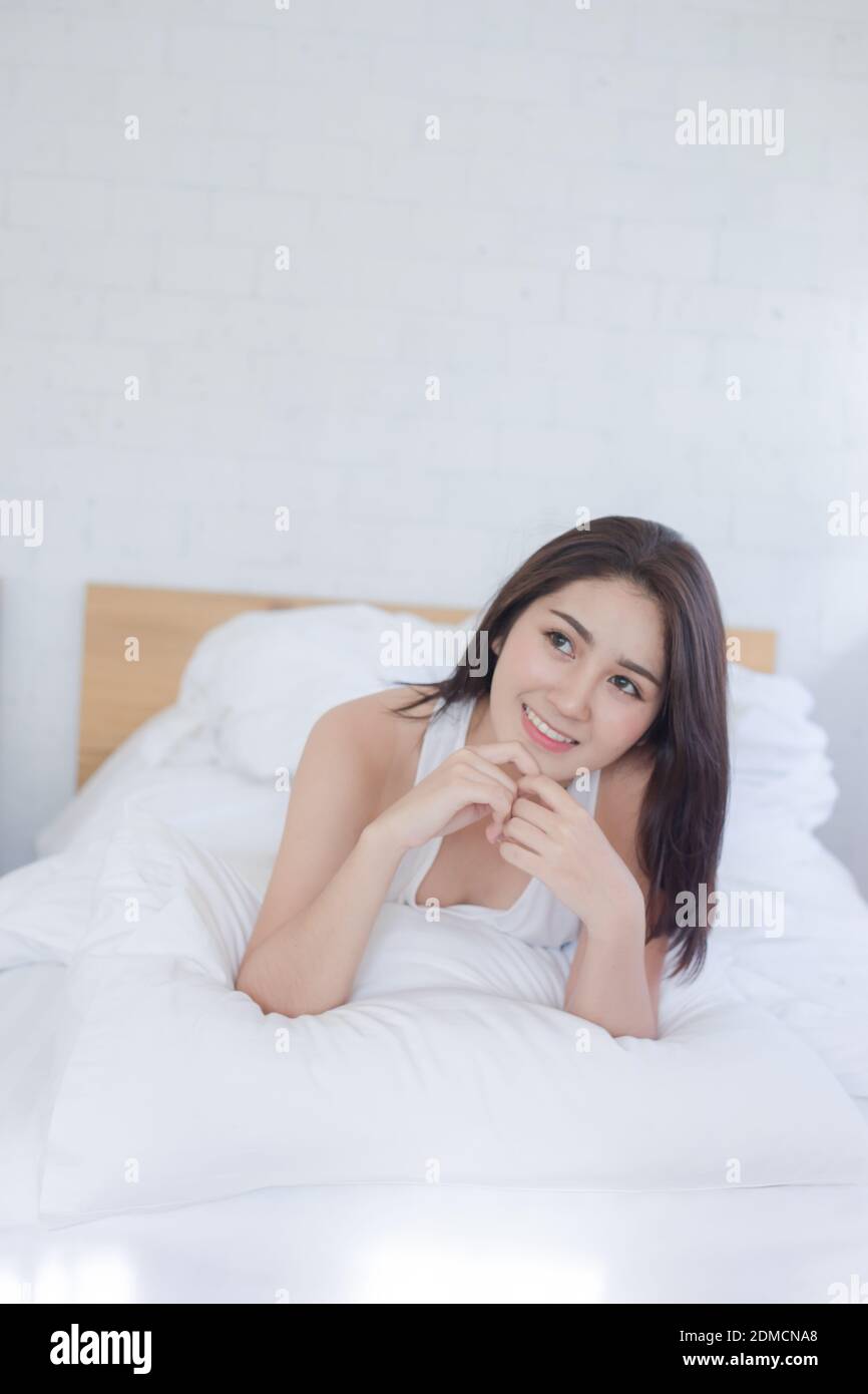 Smiling Beautiful Woman Lying On Bed At Home Stock Photo