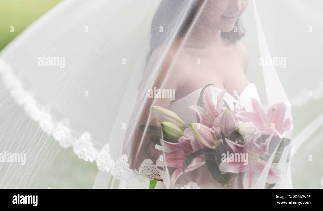 Midsection Of Bride Holding Flowers While Standing Outdoors Stock Photo
