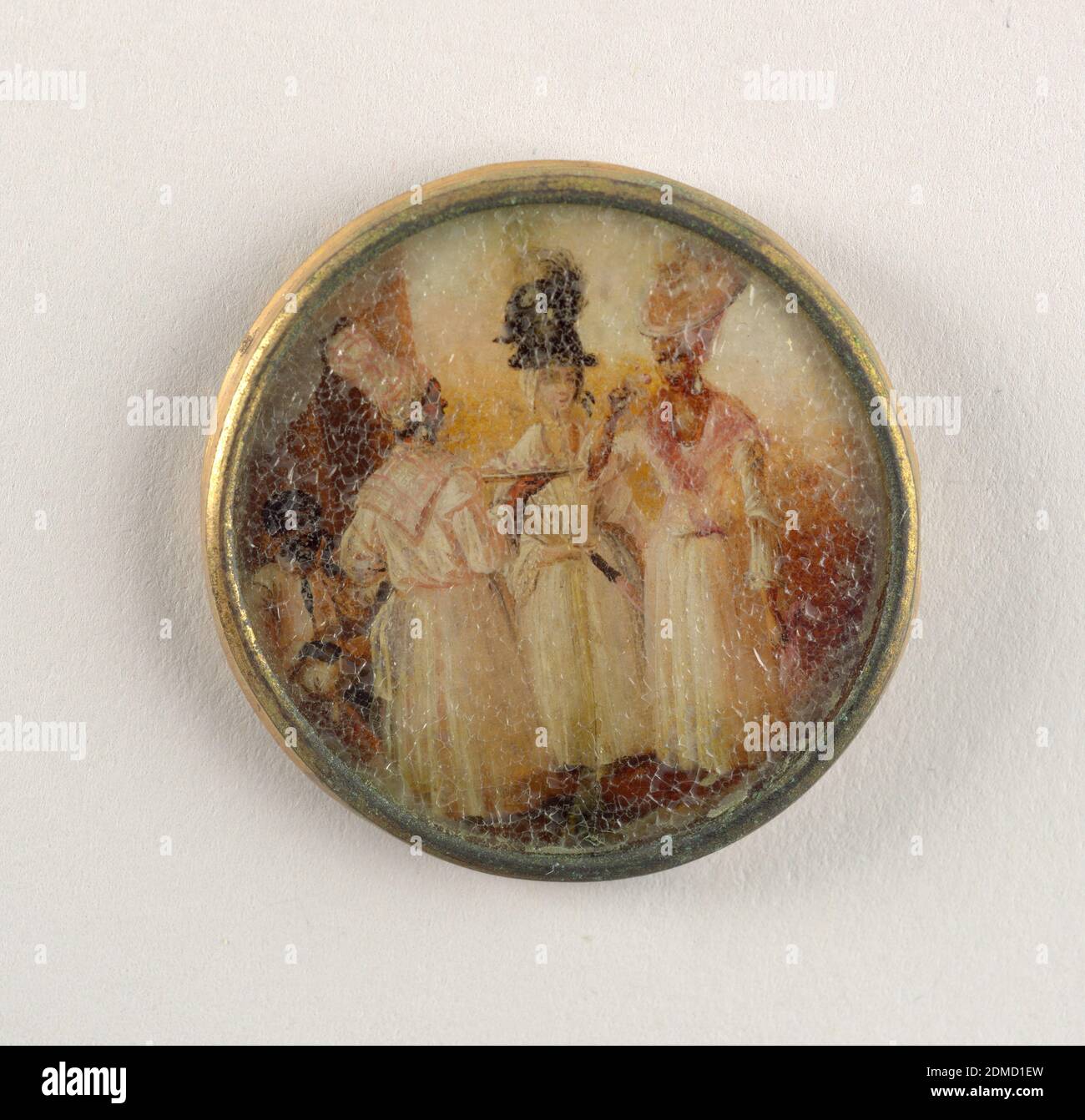 Button, Gouache paint on tin verre fixé, ivory (backing), glass, gilt metal, Button depicting scene of three women in the foreground and a seated man in the background in a partial landscape. The women are all wearing white dresses, turbans and scarves around their necks. The central figure wears a dark turban and has lighter skin than the other two., late 18th century, costume & accessories, Decorative Arts, Button Stock Photo