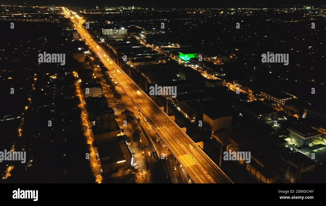 Closeup of bridge traffic highway at Manila metropolis city, Philippines. Night town street of downtown lit by lantern at light road with driving cars. Urban twilight cityscape at cinematic drone shot Stock Photo