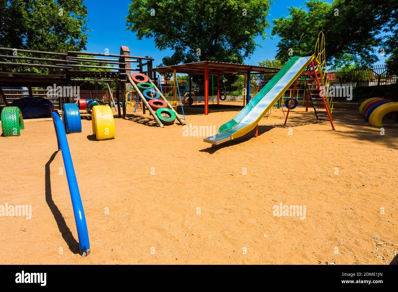 The colorful slides and swings on the playground in a park Stock Photo Alamy