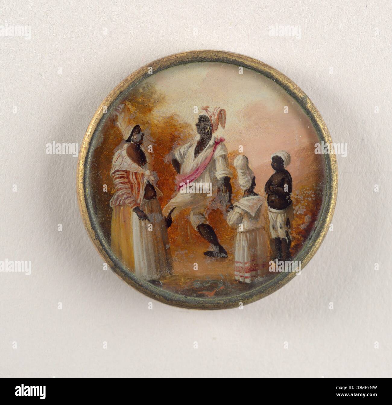 Button, Gouache paint on tin verre fixé, ivory (backing), glass, gilt metal, Button depicting scene of four figures in a landscape. A woman on the left wears a striped shirt and scarf, an orange and white skirt and turban; she faces man who is dancing (marching?) and wears a white shirt with pink sash and red and white scarf on head. Two smaller figures stand to the side watching., late 18th century, costume & accessories, Decorative Arts, Button Stock Photo