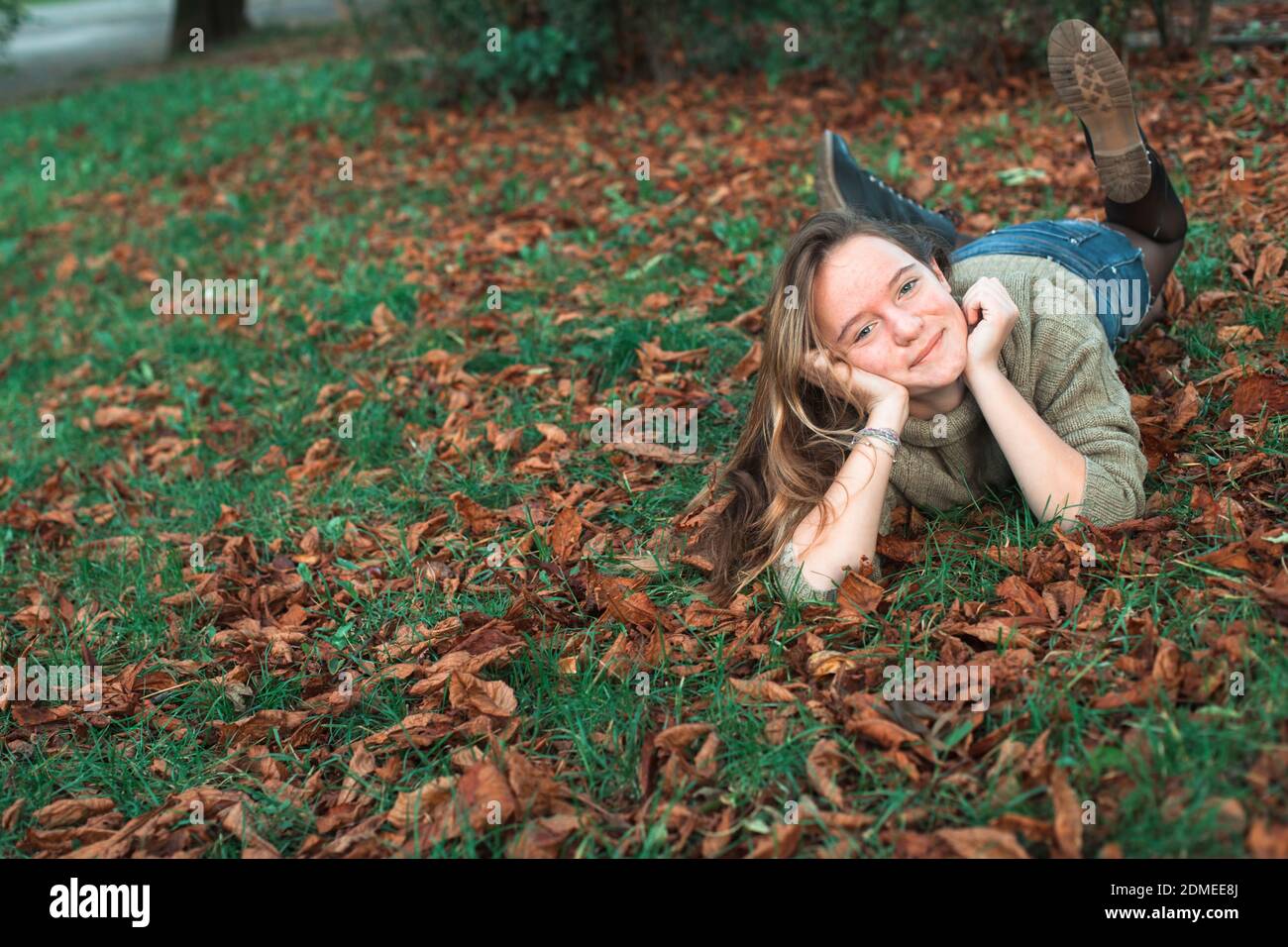 Teen girl lying on the fallen yellow leaves in autumn park Stock Photo ...