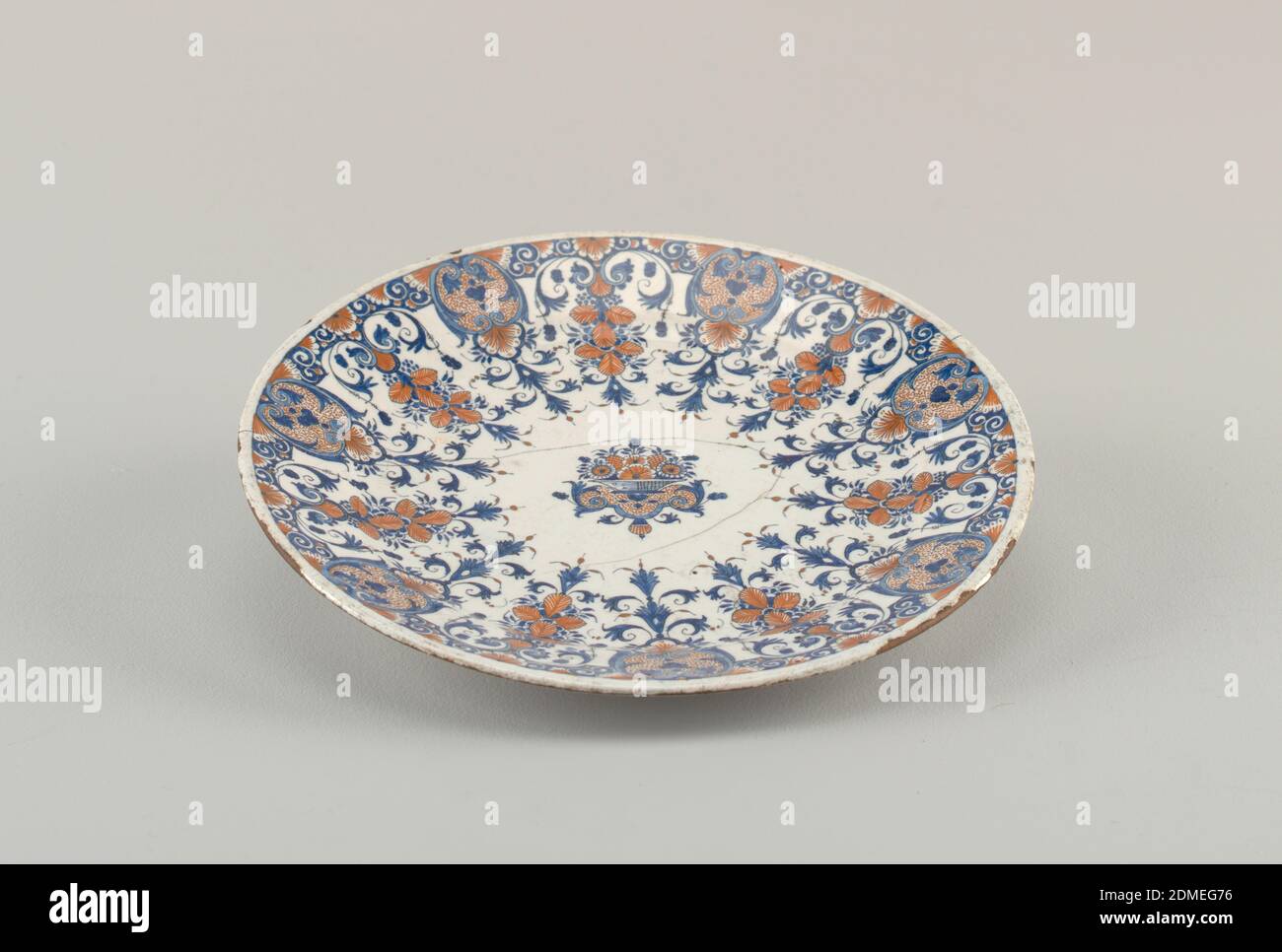 Plate, Tin-glazed thrown earthenware, Circular; lambrequin border and  central basket of flowers in terracotta color and blue on white ground.,  Rouen, France, 1710–30, ceramics, Decorative Arts, Plate Stock Photo - Alamy