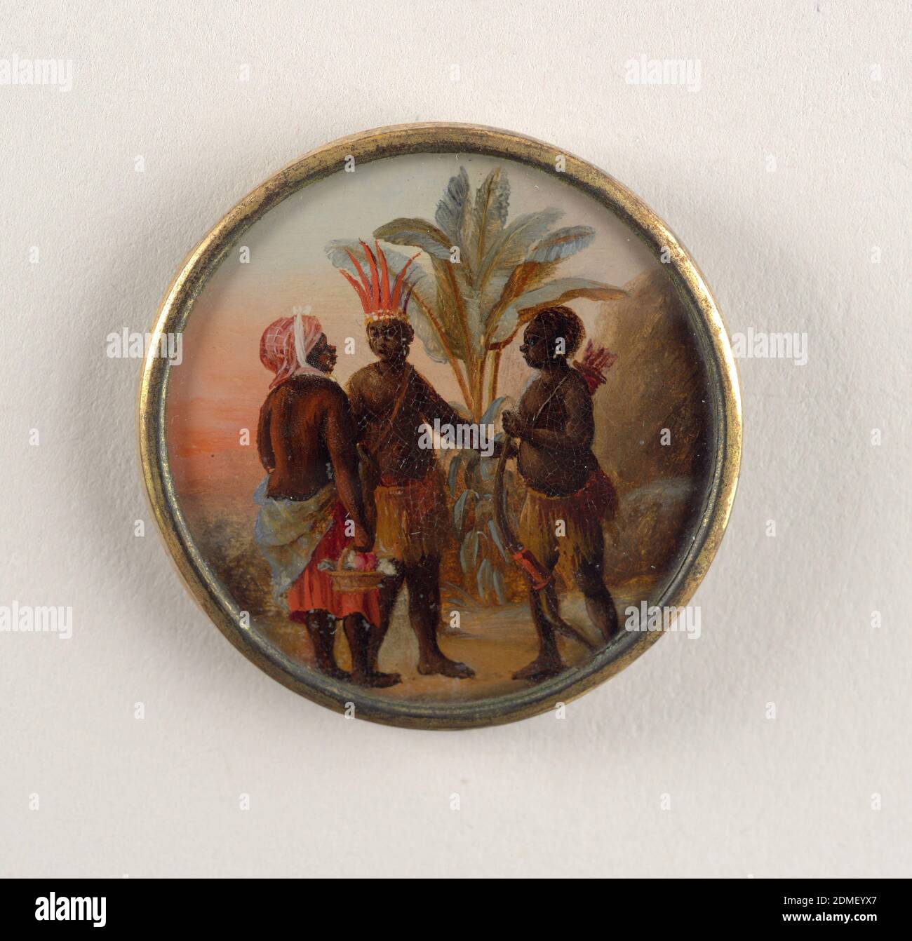 Button, Gouache paint on tin verre fixé, ivory (backing), glass, gilt metal, Button depicting scene with three figures in a palm tree-filled landscape conversing. Two men wear native West Indies garments of skirts; one wears a red feathered crown; the other holds a bow and carries a quiver of arrows on his back. Woman on the left wears a Western skirt with no shirt and a red scarf on head; her back is towards the viewer and she carries a basket of flowers., late 18th century, costume & accessories, Decorative Arts, Button Stock Photo